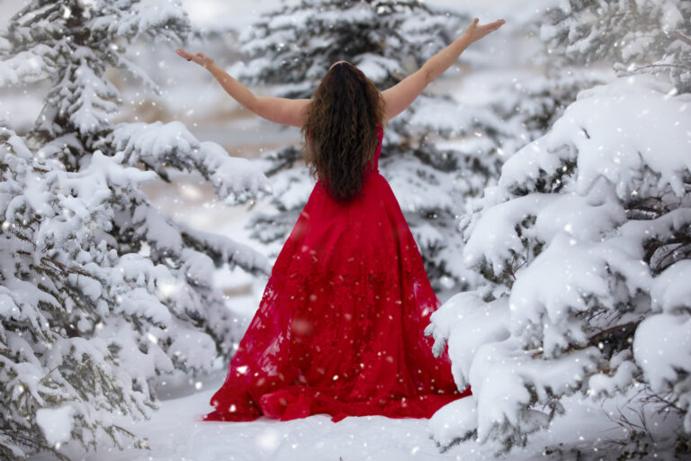 Kristen Scott dancing in snow from behind in a red ball gown